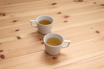 無垢材のテーブルと2つのカップ　二人　２人　茶　紅茶　休憩　リラックス　斜め上　ペア　話す　会話　コミュニケーション　余白　コピースペース　文字スペース