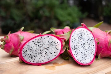 Organic white fresh dragon fruit cut into half on wooden chopping board