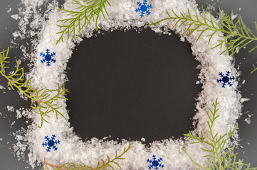 Flat lay christmas picture. A wreath of snow on a black background.