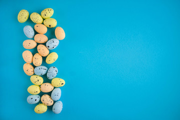 Flat lay pictures for Easter. Miniature eggs on a pink and blue background and copy space.