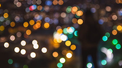 Abstract image of blurred, bokeh lights and out of focus person