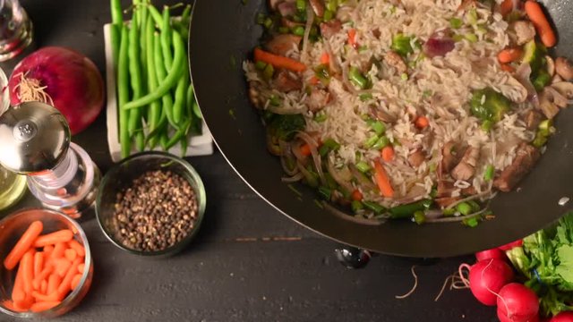 cooking rice with vegetables and meat on a black background, Flat lay