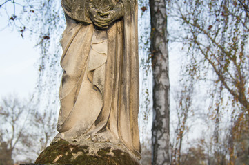 Fototapeta na wymiar Monument and candles in the cemetery. All Saints Day in Poland. Stone statue. 
