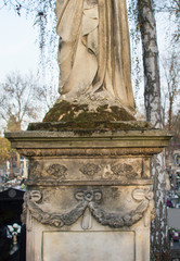 Obraz premium Monument and candles in the cemetery. All Saints Day in Poland. Stone statue. 
