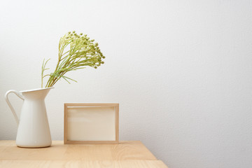 白背景　無垢材　机　写真　フレーム　観葉植物　白い壁　木製テーブル　写真立て　空白　余白　コピースペース　文字スペース　背景素材　背景　爽やか　シンプル　ナチュラル　ベージュ　ホワイト　黄緑　ライトグリーン　