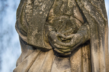 Monument and candles in the cemetery. All Saints Day in Poland. Stone statue. 