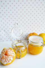 yellow jar of honey with peeled tangerine