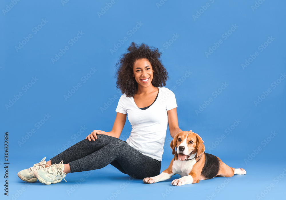 Canvas Prints Beautiful African-American woman with cute dog on color background