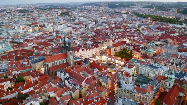 Aerial footage Church of Our Lady in old town district of Prague at twilight. Drone circling above famous cathedral. Panorama night city with illuminated streets and buildings. Lateral motion shot