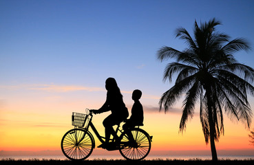 Obraz premium silhouette happy family ride bike on sunrise
