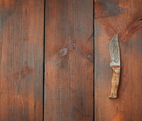 vintage steel sharp knife on a brown wooden table made of boards