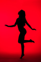 Fototapeta na wymiar black silhouette of sensual woman on red