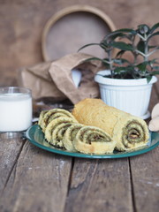 pastry roll on a green plate with ingredients on a brown background