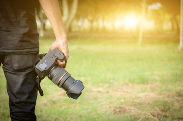 photographer holding a camera in his hand in the forest.
