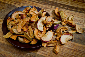 Dried sliced apples, healthy, closeup shot on a wooden surface.