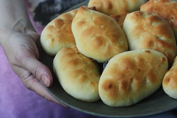 Delicious fresh pies with jam in hand 