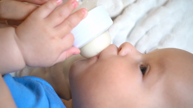 Close-up of a child eating from a bottle, 4K