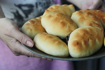 Delicious fresh pies with jam in hand 
