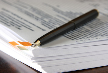 Ballpoint pen on a stack of documents