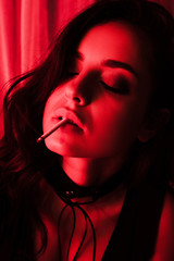 beautiful sexy woman smoking cigarette in red light