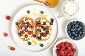Sandwiches with curd cheese, blueberries, raspberries and honey