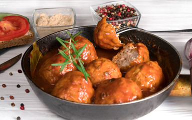 Beef cutlets with spices for fast food in a frying pan on a white background.