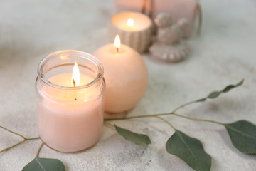 Obraz na płótnie Canvas Glowing candles with eucalyptus on table