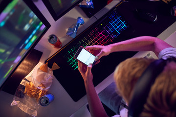 Overhead View Of Teenage In Front Of Computer Screens Trolling On Social Media
