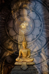 Obraz premium A peaceful Golden Buddha statue superimposed and double exposured with Wheel of Dhamma. Buddha statue from Wat Pathum Wanaram, Bangkok, Thailand, is posing “The attitude of subduing Mara