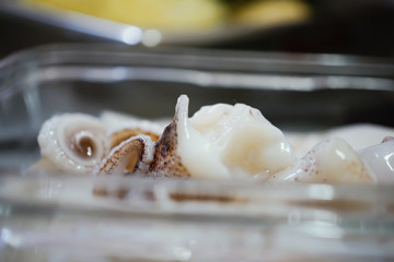 Fototapeta na wymiar blur fresh squid inside transparent glass plate