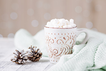 Obraz na płótnie Canvas Mug with coffee and marshmallow, sweater, cinnamon. Cozy christmas composition. Hygge concept Soft focus