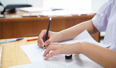 Evaluation or measurement concept. Student testing in exercise taking fill in exam at school or university in test room, writing document exams paper at campus classroom, education back to school idea