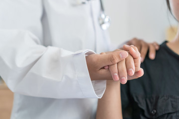 Doctor's hands holding female patient hand for reassuring with friendly encouragement empathy for...