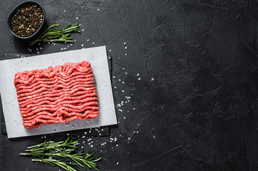 Raw minced marble beef. Black background. Top view. Space for text