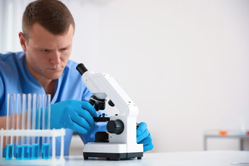 Scientist using modern microscope at table. Medical research