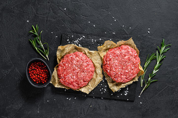 Ground raw meat patties. Meat patties ready to cook. Barbecue party.  Farm organic meat. Black...
