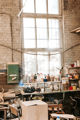 Obraz na płótnie Canvas dusty workshop with brick walls and bottles on table