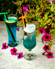 two glasses of blue drinks with plastic straw pipes