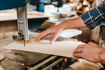 cropped view of woodworker using cnc machine in workshop
