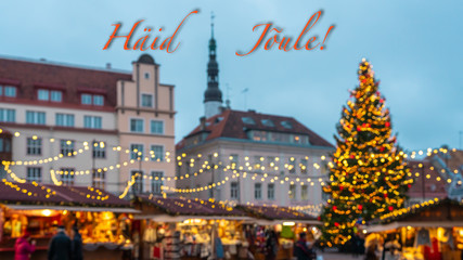 Fototapeta na wymiar Merry Christmas and New Year wishes in Estonian. Blurred background of the main square of old Tallinn city with a beautiful Christmas market and decorated fir tree. Happy New year 2020. Illuminated. 