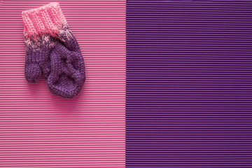 Children's winter mitten is on a pink and purple background. Handmade.