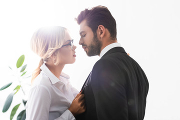 Side view of businessman and businesswoman looking at each other while flirting in office