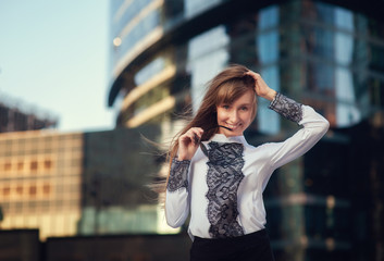 Fototapeta premium Summer portrait of a beautiful girl with long hair on the background of Moscow City