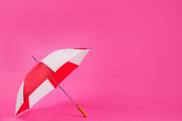 Colorful umbrella on pink background. Space for text