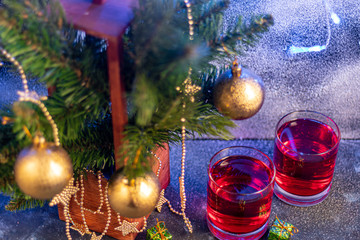 Fototapeta na wymiar Celebratory drink, rose wine on a dark background. New Year's props, artificial snow. Copy space. 