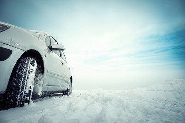 Car on winter snowy road in mountains in sunny day