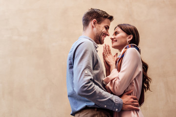 happy young woman looking at boyfriend and showing please gesture