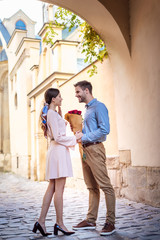 young man presenting bouquet of roses while making marriage proposal to girlfriend on street