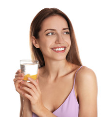 Young woman with glass of lemon water on white background