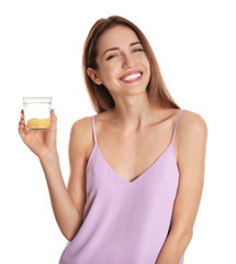 Young woman with glass of lemon water on white background